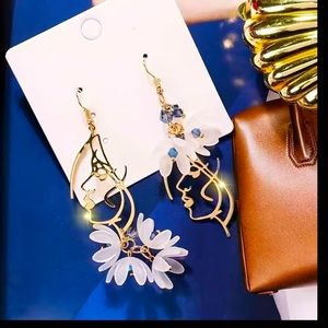 Golden Dangling Asymmetrical Earrings with off-white petals and Dali style Face